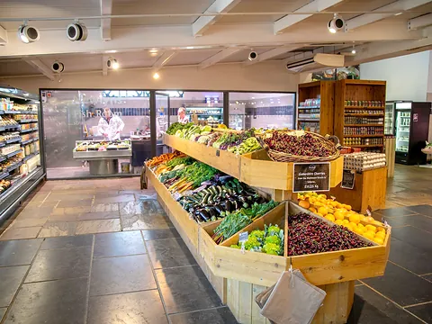 Inside Newlyns Farm Shop, with shelves and crates of fruit and vegetables