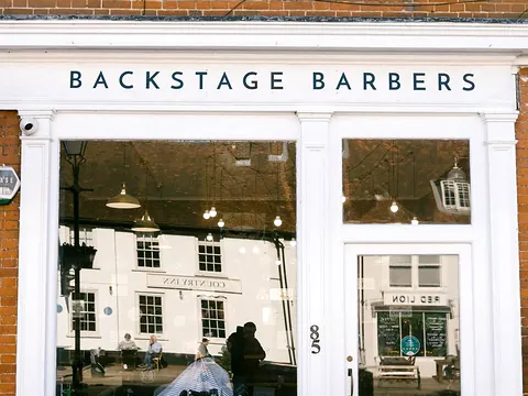 The Backstage Barbers shopfront in Odiham, with a motorbike parked outside