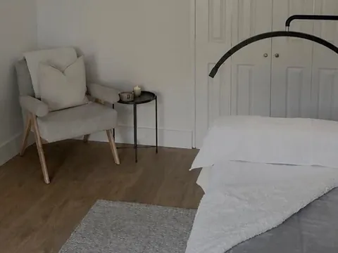 The treatment room at Beauté by Michèle, with a treatment bed, a lamp and an armchair