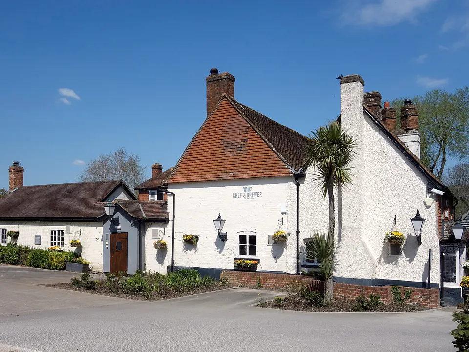 The Waterwitch, a white-painted pub with a red-tiled roof and hanging baskets, at Colt Hill in Odiham